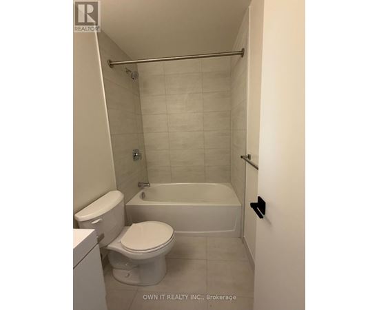 A white toilet and bathtub in a bathroom.