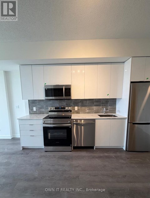 A kitchen with white cabinets and stainless steel appliances.