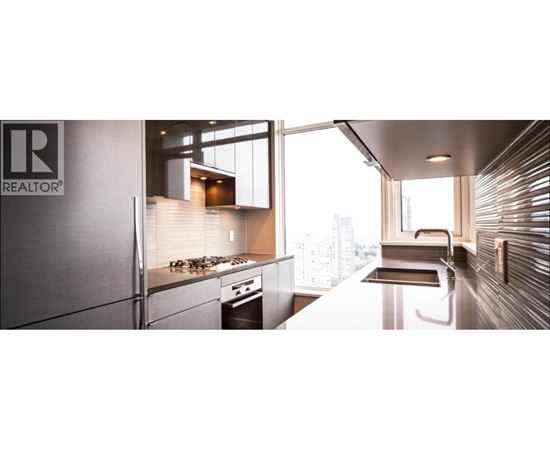 A modern kitchen with stainless steel appliances and a large window.
