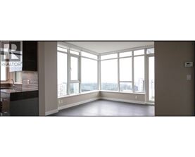 A large empty room with a view of the city through the windows.