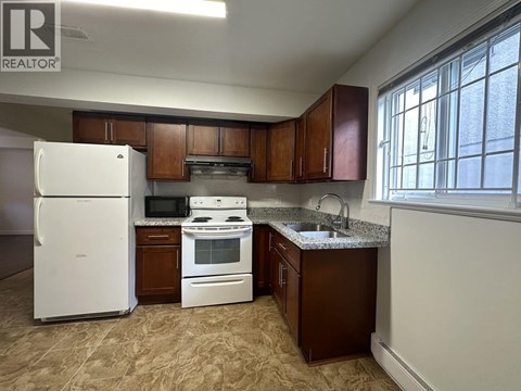 A kitchen with brown cabinets and a white refrigerator.