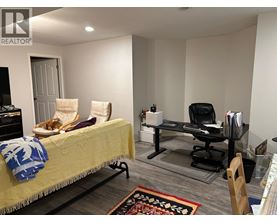 A bedroom with a bed, chair, and desk.