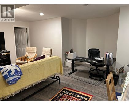 A bedroom with a bed, chair, and desk.