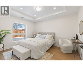 A bedroom with a large bed and a chair.
