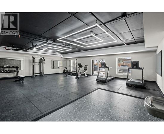 A gym with a variety of equipment including treadmills, weights, and exercise machines.