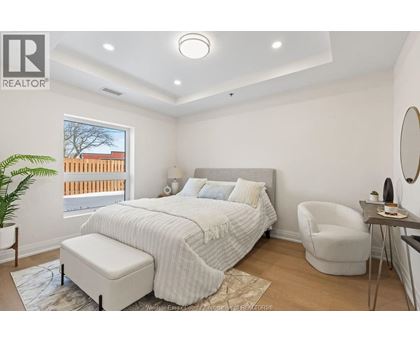 A bedroom with a large bed and a chair.