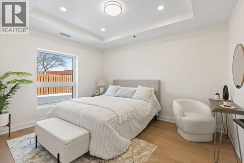 A bedroom with a large bed and a chair.