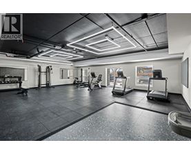 A gym with a variety of equipment including treadmills, weights, and exercise machines.