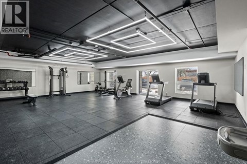 A gym with a variety of equipment including treadmills, weights, and exercise machines.