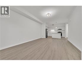 A spacious room with wooden flooring and white walls.