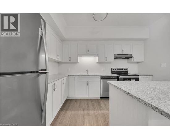 A kitchen with white cabinets and a marble countertop.