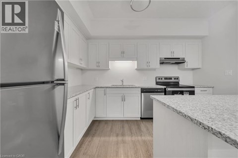 A kitchen with white cabinets and a marble countertop.