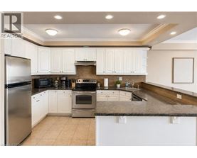 A kitchen with white cabinets and a stainless steel refrigerator.