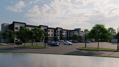 A modern building complex with a parking lot in front.