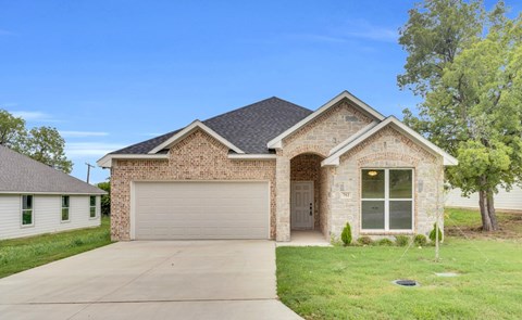 A house with a garage door and a driveway.