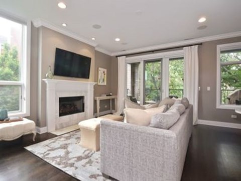A living room with a fireplace and a television on the wall.