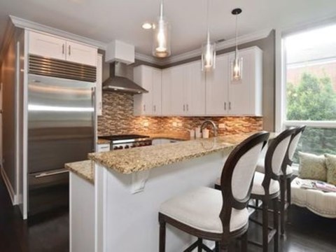 A kitchen with a granite countertop and white cabinets.