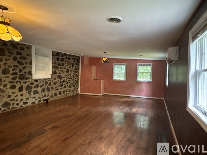 A room with wooden floors and a stone wall.