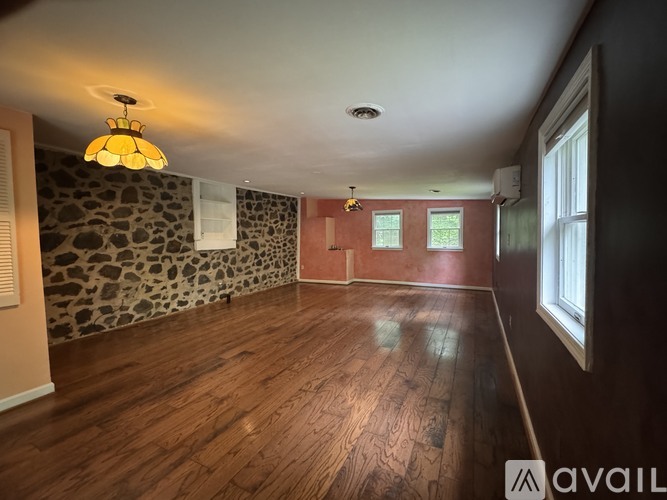A room with wooden floors and a stone wallpapered wall.