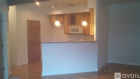A kitchen with a white counter and wooden cabinets.