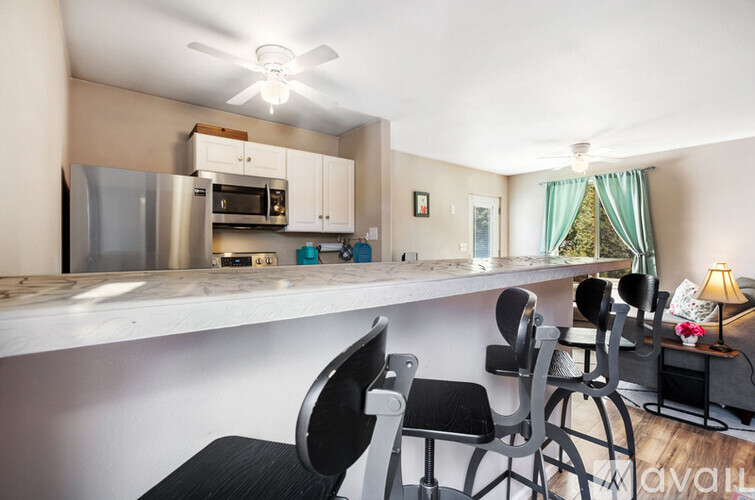 A kitchen with a bar area and chairs.