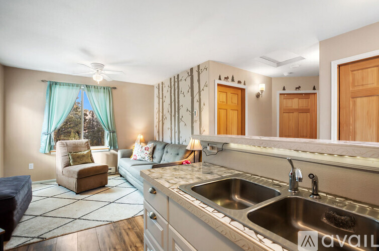 A kitchen with a sink and a window with a view of a tree.