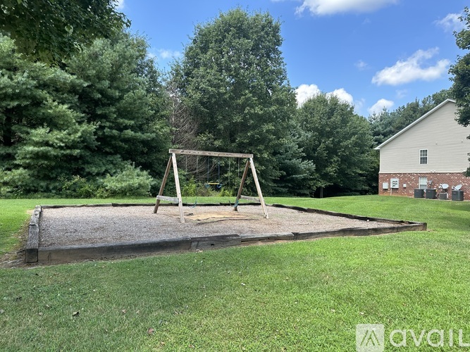 A swing set sits in the middle of a grassy yard.