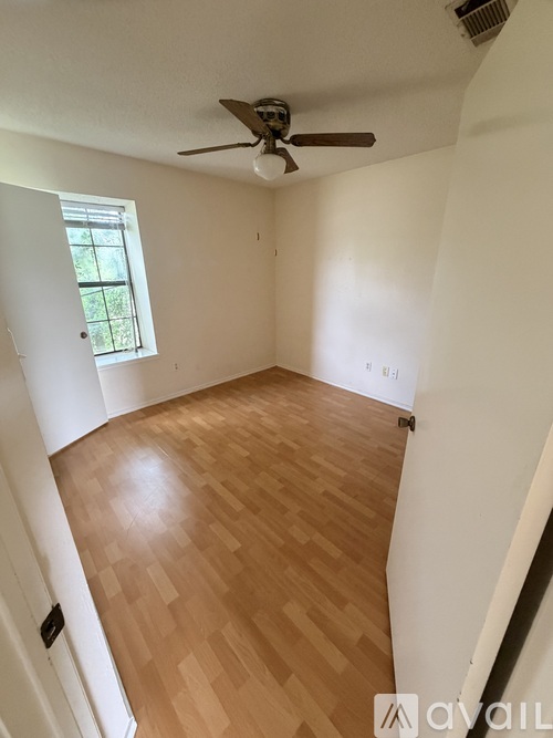 A room with wooden flooring and a ceiling fan.