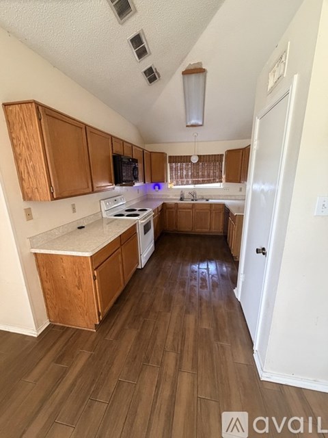A kitchen with wooden cabinets and a white stove top oven.