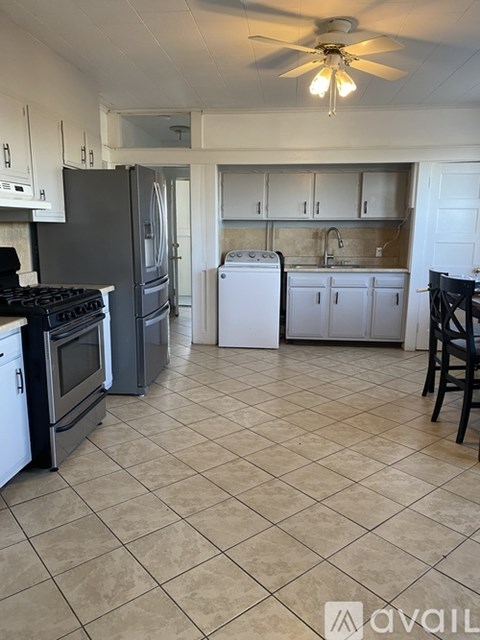 A kitchen with a black stove top oven and a black refrigerator.