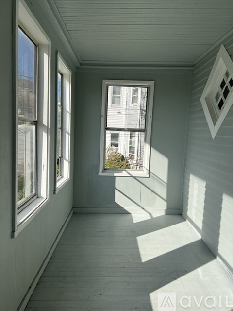 A room with a window and a view of a building outside.
