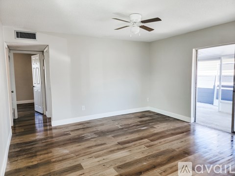 A room with wooden flooring and a ceiling fan.
