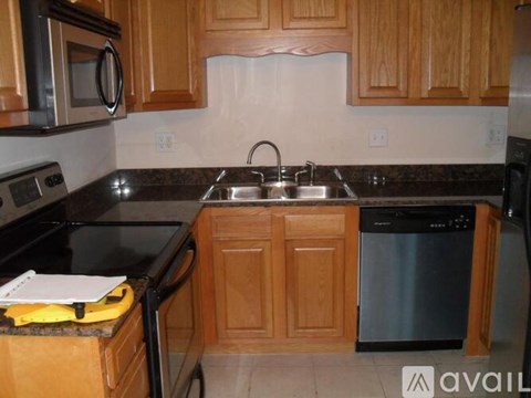 A kitchen with wooden cabinets and black countertops.