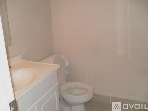 A white toilet in a small bathroom with a sink.