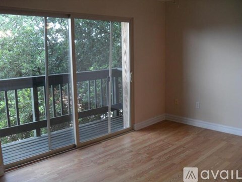 A room with a sliding glass door leading to a balcony.