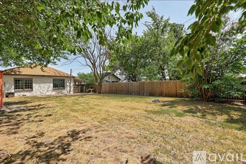 A backyard with a fence and trees.