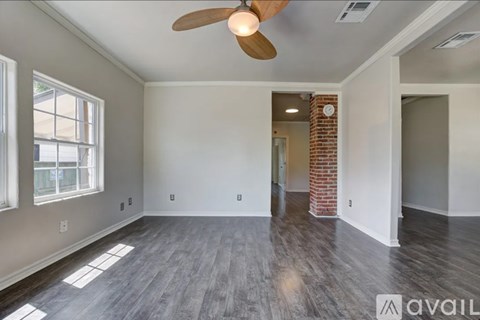 A room with a fan and a brick pillar.