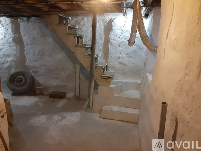 A staircase in a building with a tire and a pipe on the ground.