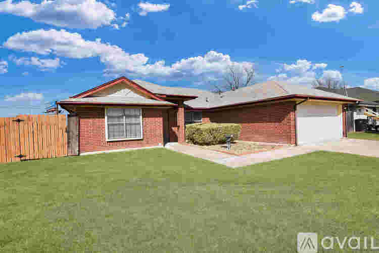 A house with a red brick exterior and a white garage door is for sale.