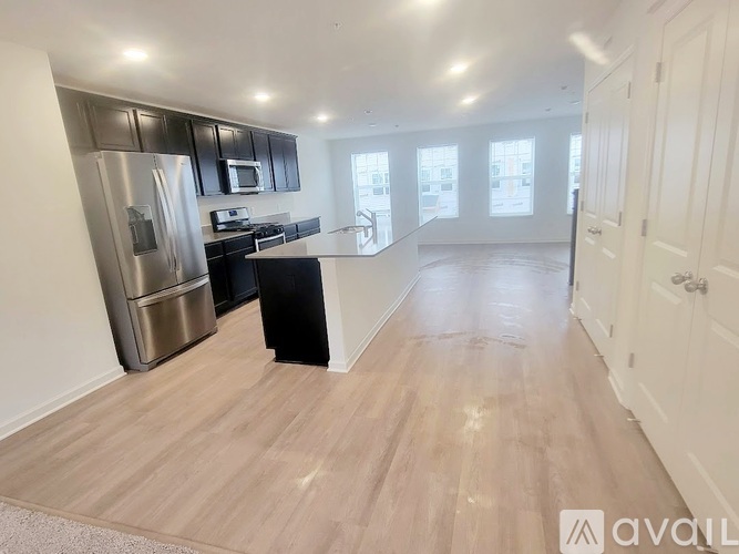 A kitchen with a refrigerator, microwave, and oven.