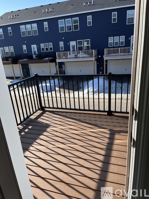 A balcony with a pool and a building in the background.
