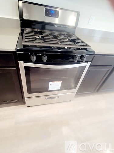 A modern stove with a digital display is in a kitchen.