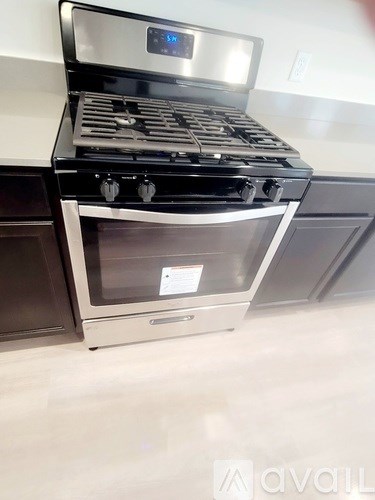 A modern stove with a digital display is in a kitchen.