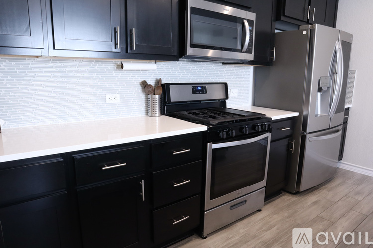 A kitchen with black cabinets and a white countertop.