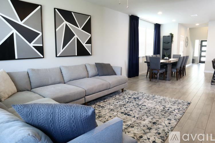 A living room with a grey sofa and a patterned rug.