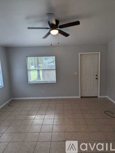 A room with a ceiling fan and tile flooring.