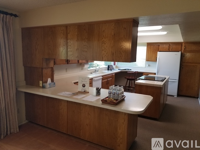 A kitchen with wooden cabinets and a white refrigerator.