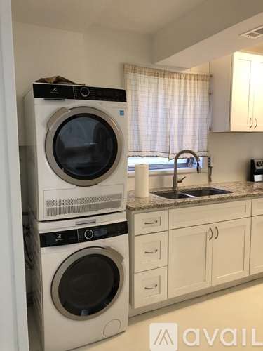 A stack of two washing machines in a kitchen.