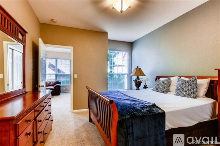 A bedroom with a bed, nightstand, and a window.