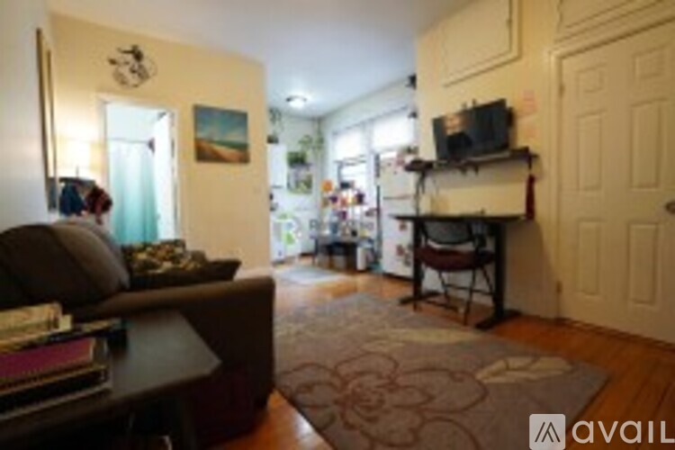 A living room with a brown couch and a rug.